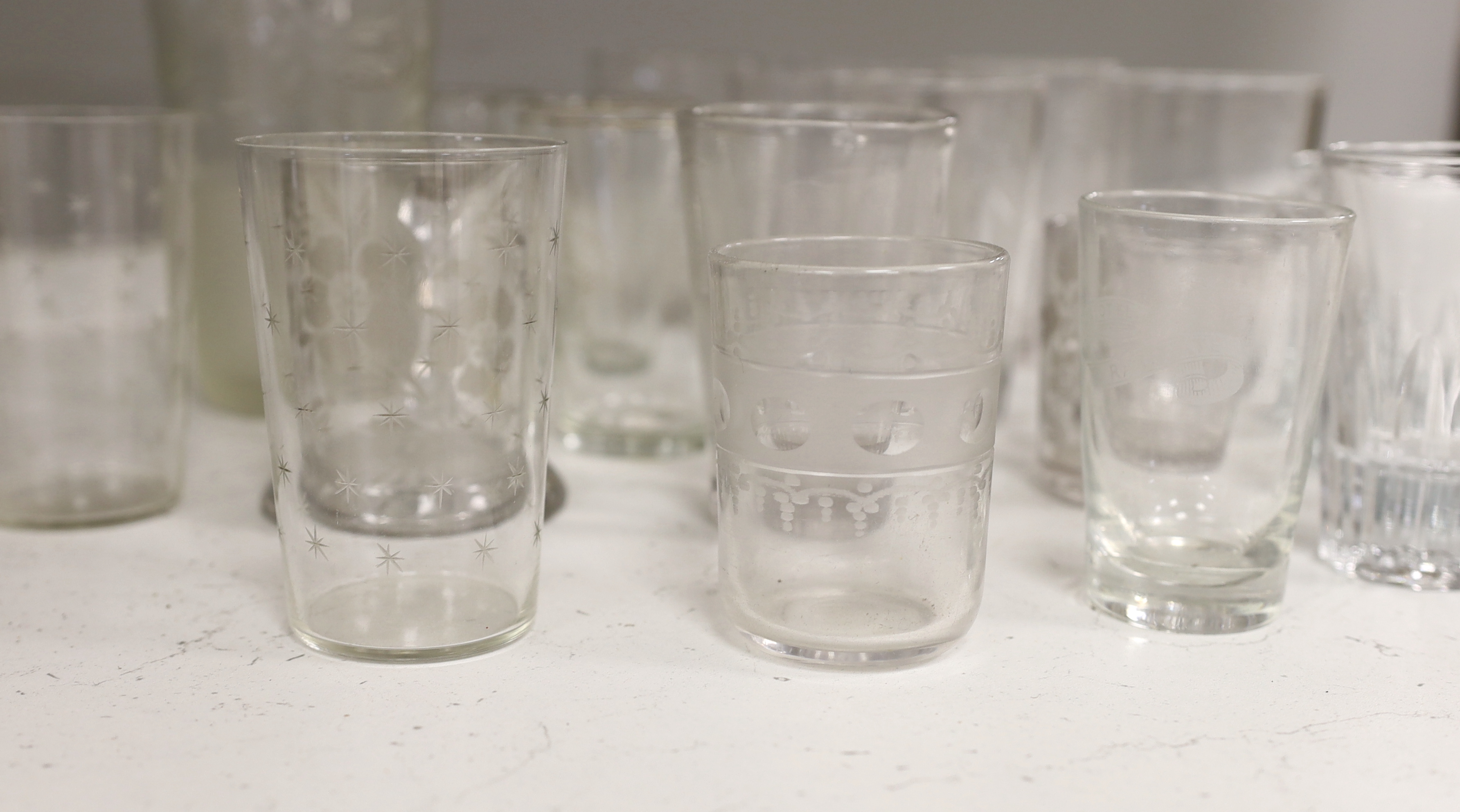 A collection of 19th and early 20th century drinking glasses, including beakers, some etched examples, half pint ale mug, an etched glass jug, etc., tallest 17cm (20)